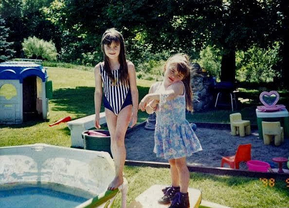 Christina in a blue-striped swimsuit and Kim in a flowered dress in the backyard at Westfield, August 1998
