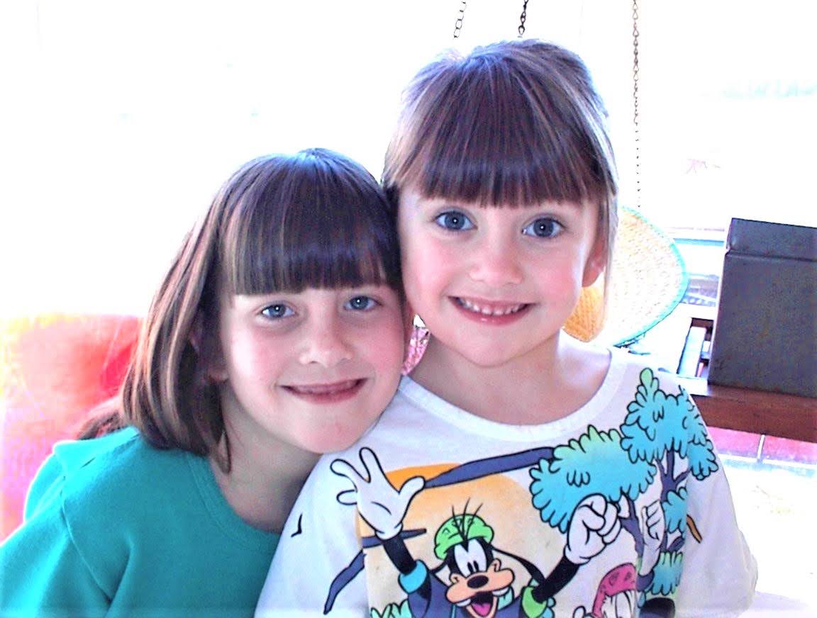 Christina (left, teal sweater) and Kim (right, Goofy T-shirt) smiling together, mid-1990s
