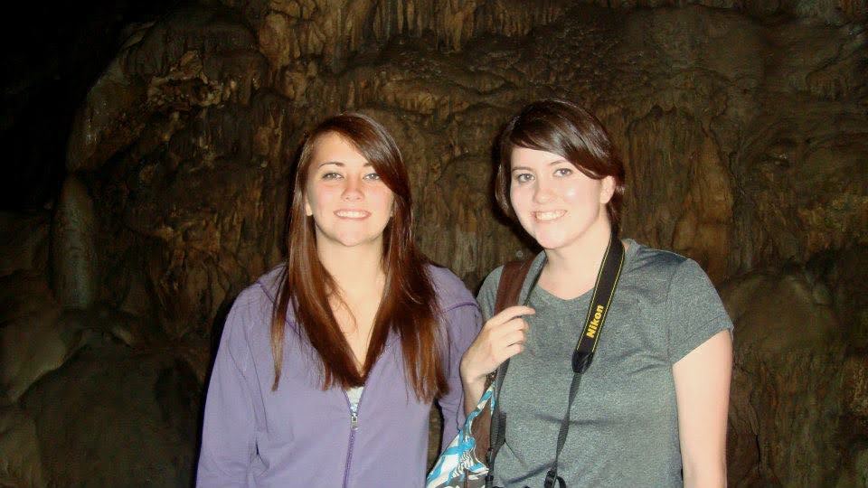Christina (left, purple hoodie) and Kim (right, gray t-shirt with Nikon camera around her neck) smiling together inside Indian Echo Caverns, Hummelstown PA, August 2012