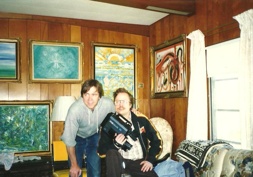 Larry (left) with his brother Mark in 1991, paintings hung around them