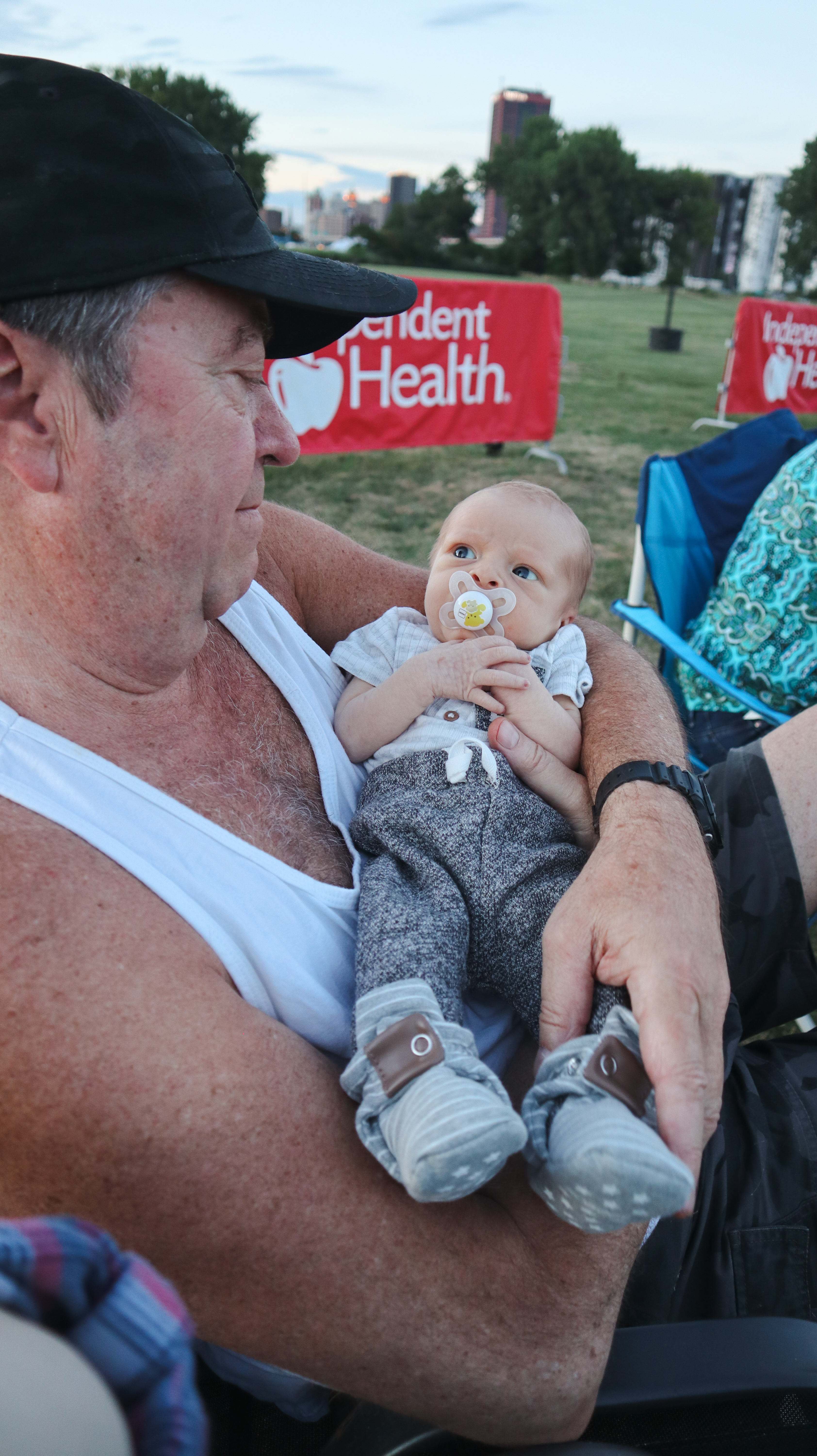 Larry holding baby Nova outdoors at a Buffalo event, 2022