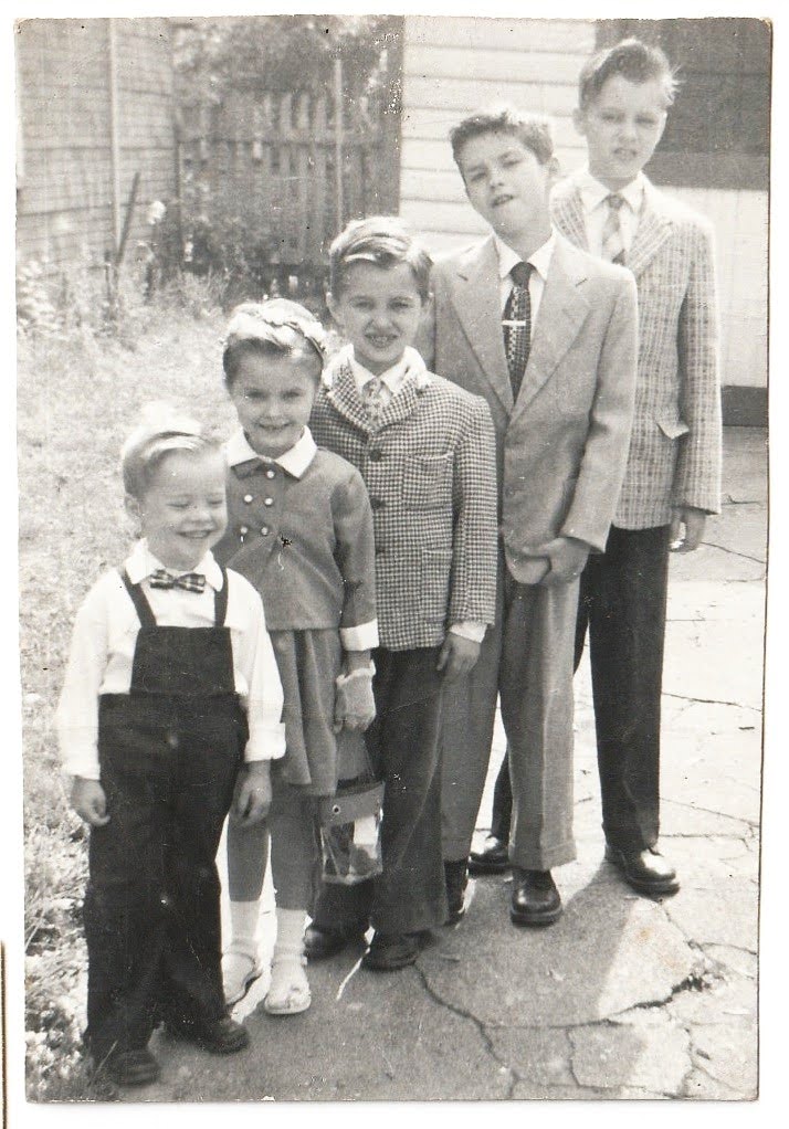 Larry in the yard with his siblings, all dressed up. Larry, front.