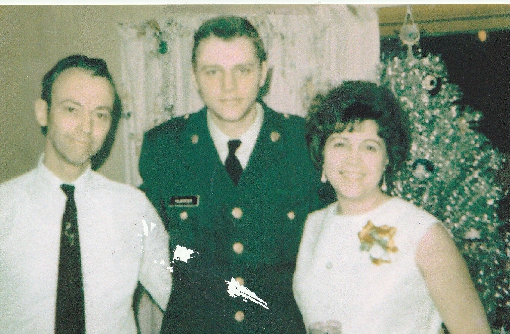Edwin, Mike in Army uniform, and Rosa by the Christmas tree