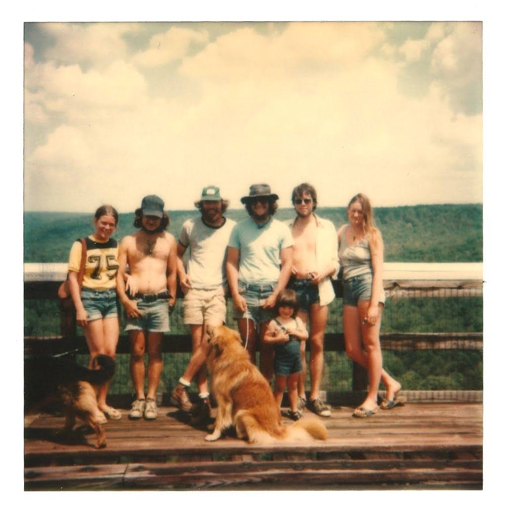 Group of friends and family on a wooden overlook with dogs