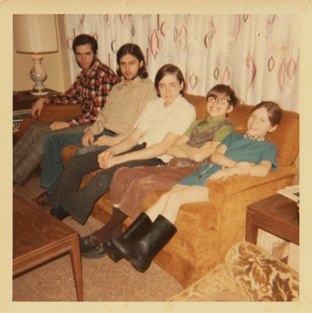 Larry with his siblings sitting on a couch