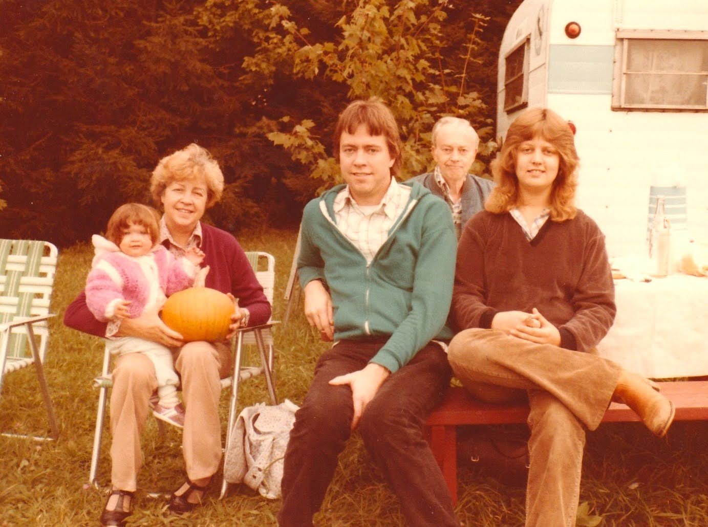 Dawn (on Rosa's lap with a pumpkin), Rosa, Larry, Edwin, and Jan at Java Center with the mobile home in the background
