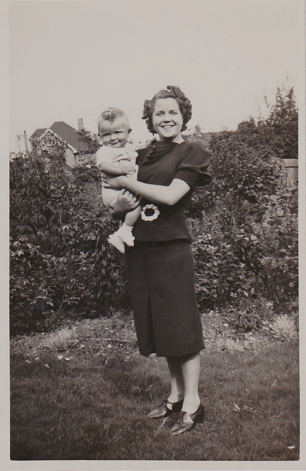 Rosa holding baby Mike in the yard